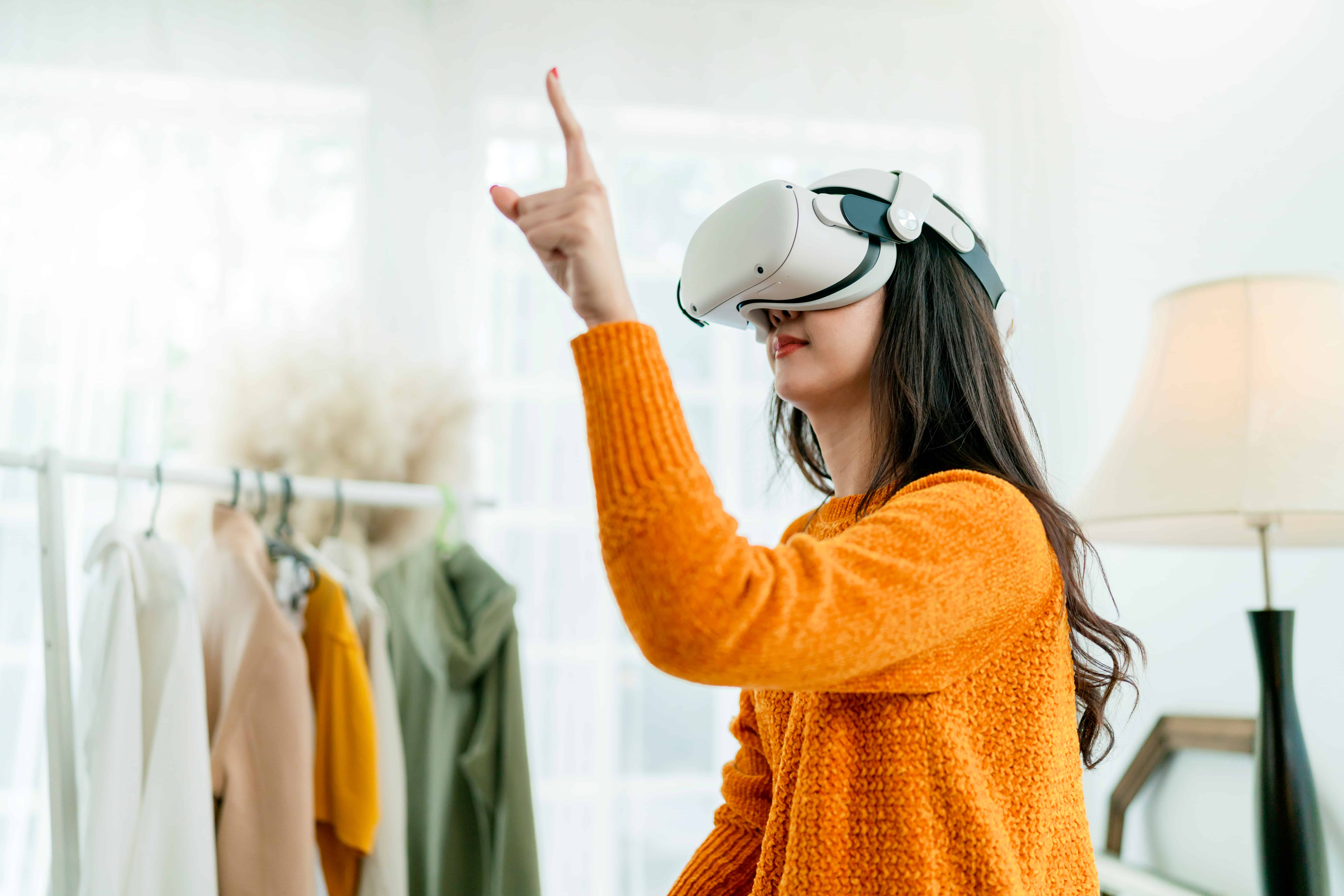 A woman trying her clothes virtually using VR headset